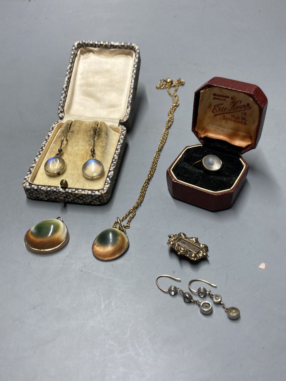 Two yellow metal-mounted shell pendants, a moonstone ring , a similar pair of drop earrings and a mourning brooch,